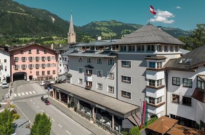 Hotel Das Reisch in Kitzbühel Blick auf das Hotel Das Reisch und das Rathaus in Kitzbühel vor einer Bergkulisse.