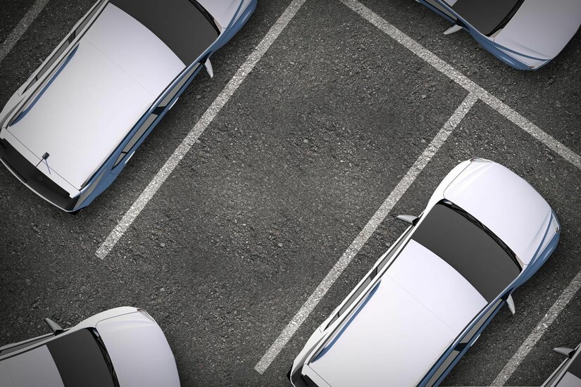 Parkplatz Resterhöhe Vogelperspektive auf einen asphaltierten Parkplatz mit weißen Markierungen und geparkten Autos.
