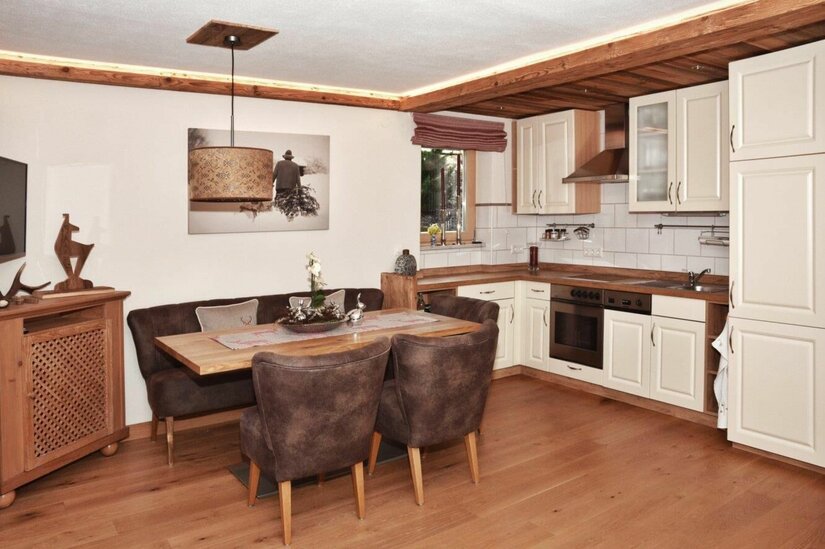 Jagahäusl Küche und Essbereich Moderne Küche mit angrenzender Essecke aus Holz und braunen Polstermöbeln.