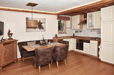 Jagahäusl Küche und Essbereich Moderne Küche mit angrenzender Essecke aus Holz und braunen Polstermöbeln.