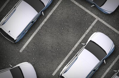 Parkplatz Ganslern P3 Draufsicht auf einen Asphaltparkplatz mit markierten Stellflächen und geparkten Autos.