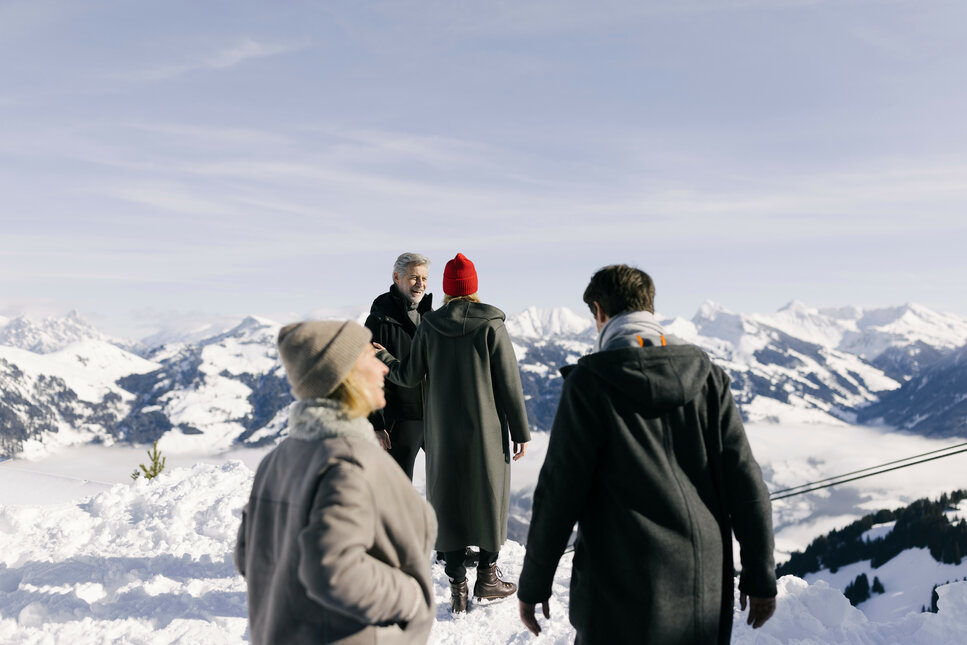 Four people are going on a winter hike in Kitzbühel