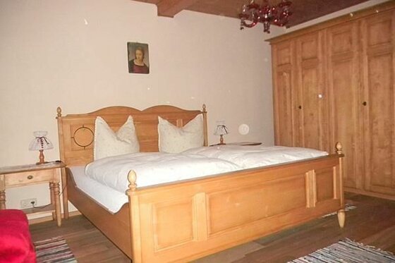 Doppelzimmer im Seiwaldhof Rustikales Doppelbett aus hellem Holz mit weißer Bettwäsche und passendem Kleiderschrank.