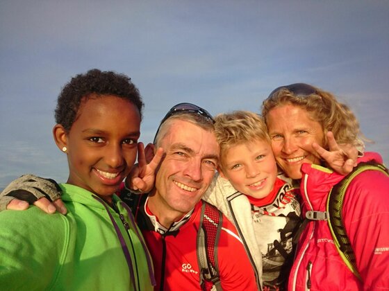 Familie Maier beim Ausflug Vierköpfige Familie in Sportkleidung macht ein Selfie im Freien.