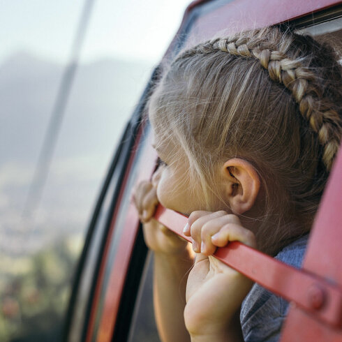 A girl looks down at Kitzbühel from the gondola