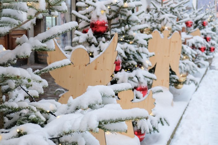 Christbäume und Holzengel mit Schnee bedeckt