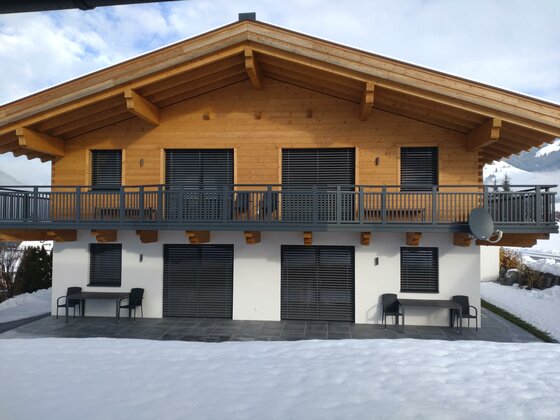 Winterbild Ferienhaus Reiter Modernes Ferienhaus in Holzbauweise mit Balkon und Terrasse im Schnee.