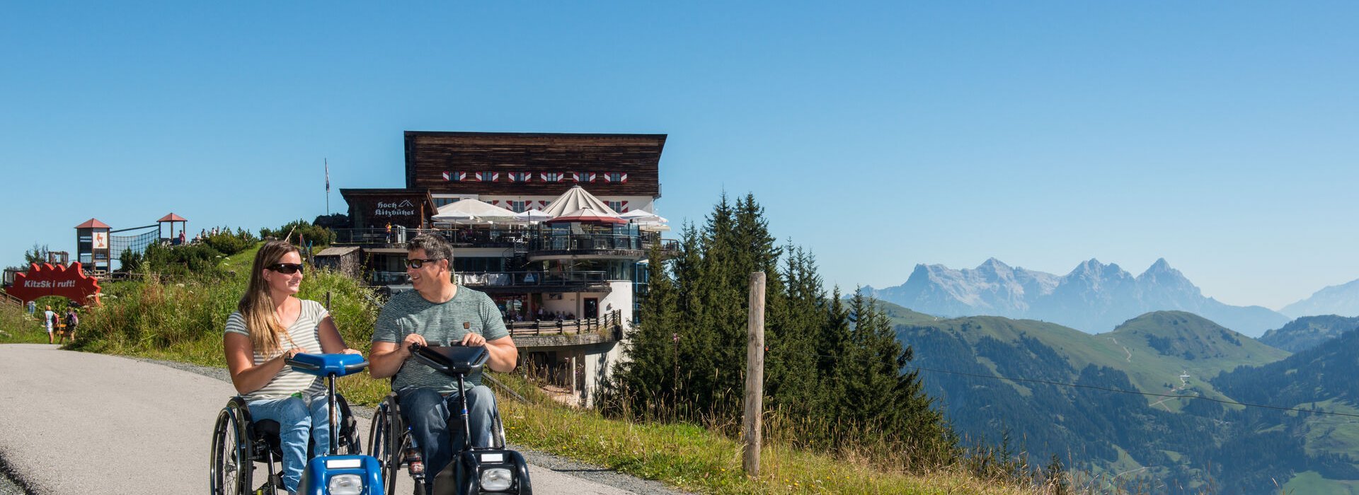 Paar im Rollstuhl vor Bergpanorama