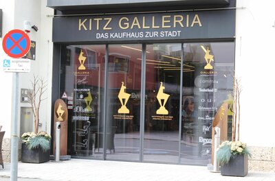 Eingang Kitz Galleria Eingangsbereich der Kitz Galleria mit Glastüren und goldenen Logos.