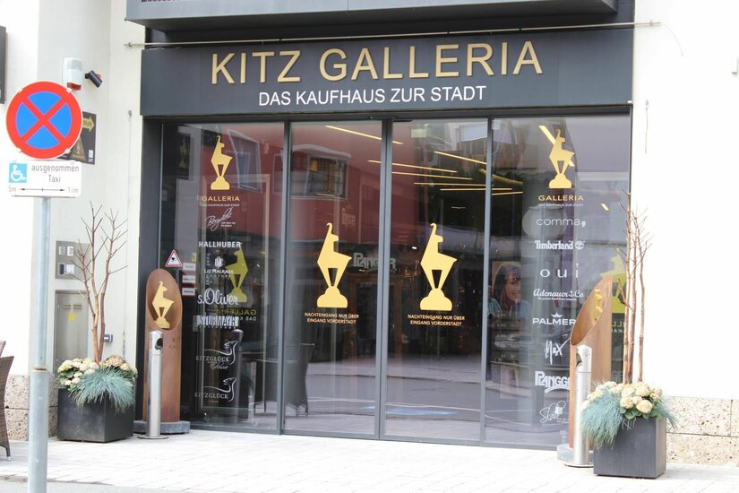 Eingang Kitz Galleria Eingangsbereich der Kitz Galleria mit Glastüren und goldenen Logos.
