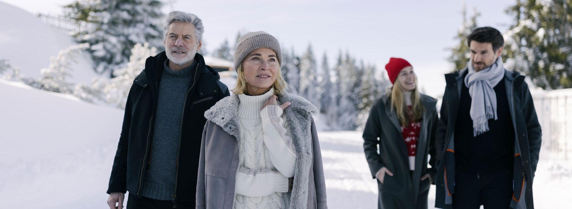 A family goes hiking in winter in a snowy landscape