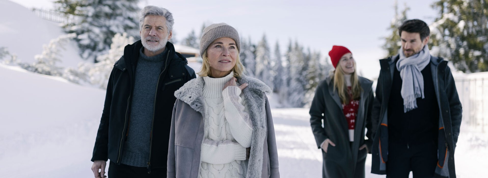 Eine Familie geht wandern im Winter in einer verschneiten Landschaft
