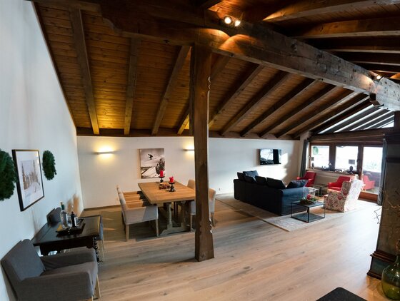 Essbereich und Salon Großzügiger Wohn- und Essbereich mit Holzbalkendecke, Esstisch und Sofaecke.