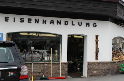 Salvenmoser Eisenwaren Außenansicht einer Eisenhandlung mit Schaufenster, Besen vor der Tür und dem Schriftzug Eisenhandlung.