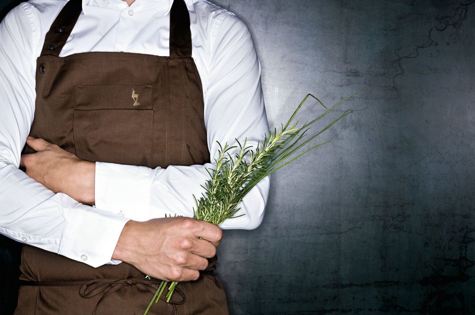 Koch mit frischen Kräutern in der Hand