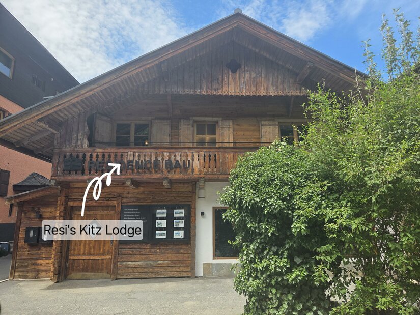 Resi's Kitz Lodge Hausansicht Vorderansicht eines traditionellen Holzhauses mit Balkon und Schaukasten im Erdgeschoss.