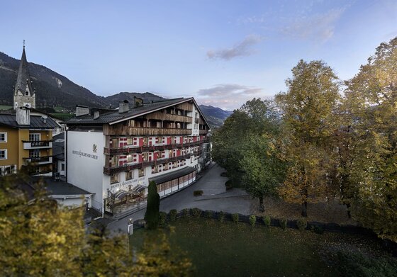 Hotel Goldener Greif Außenansicht Außenansicht des Hotel Goldener Greif mit Holzbalkonen vor herbstlichen Bäumen und Bergen.