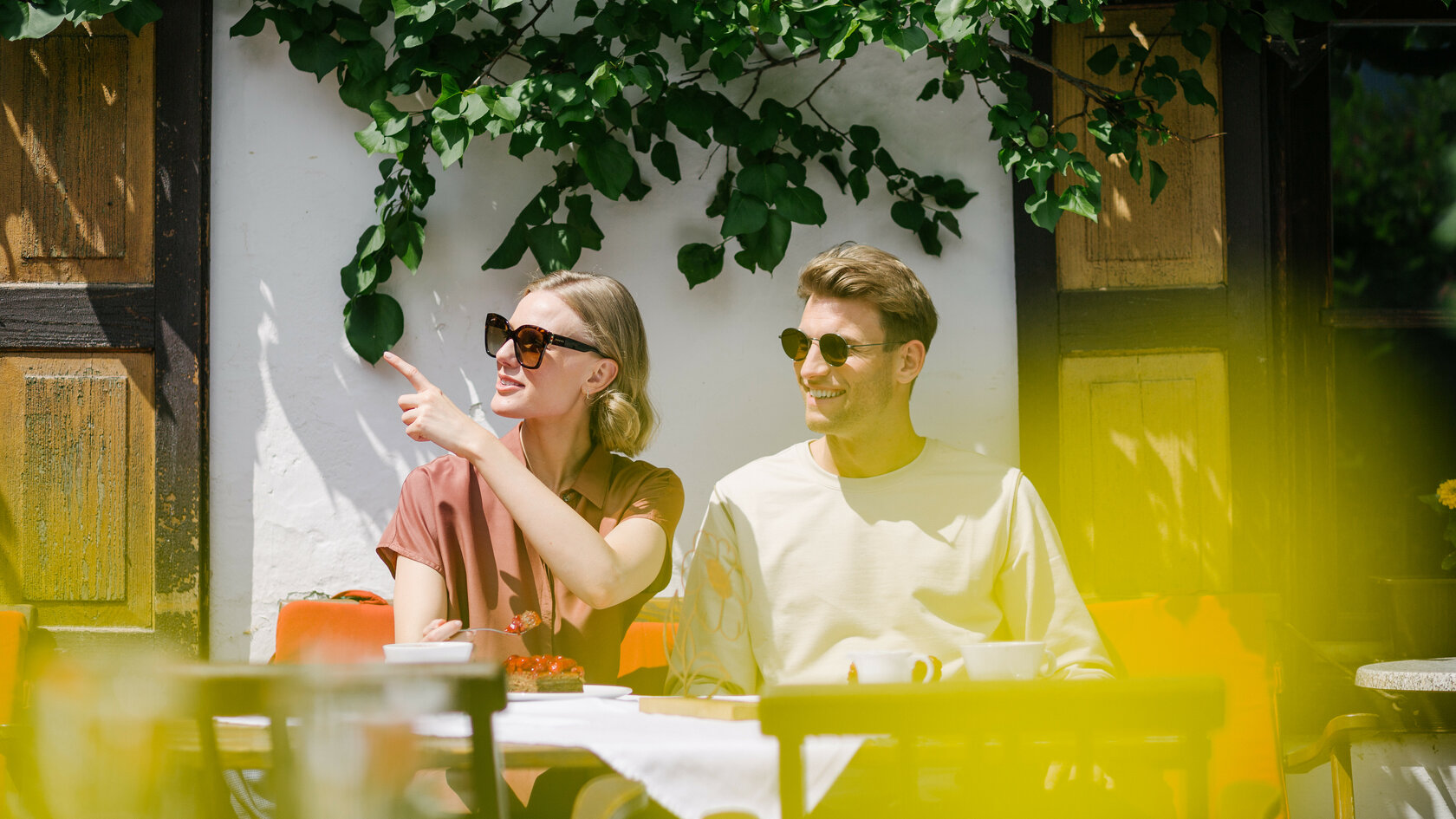 A couple is sitting on a bench in front of a house in Kitzbühel