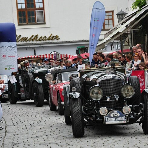 Klassische Autos bei der Alpin Rallye in Kitzbühel, Zuschauer beobachten die Szene.