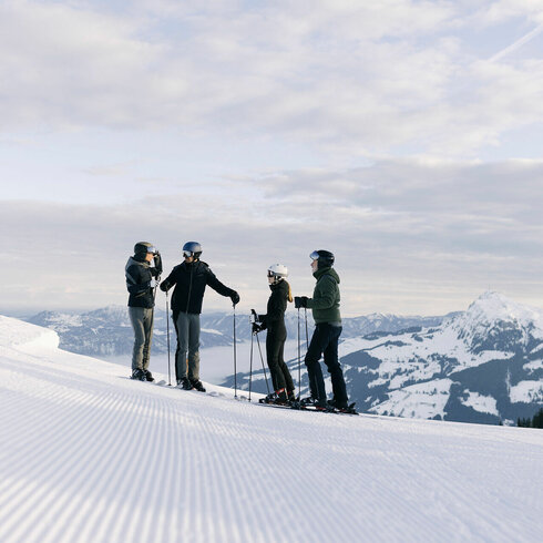 Familie steht auf der Piste beim Skifahren