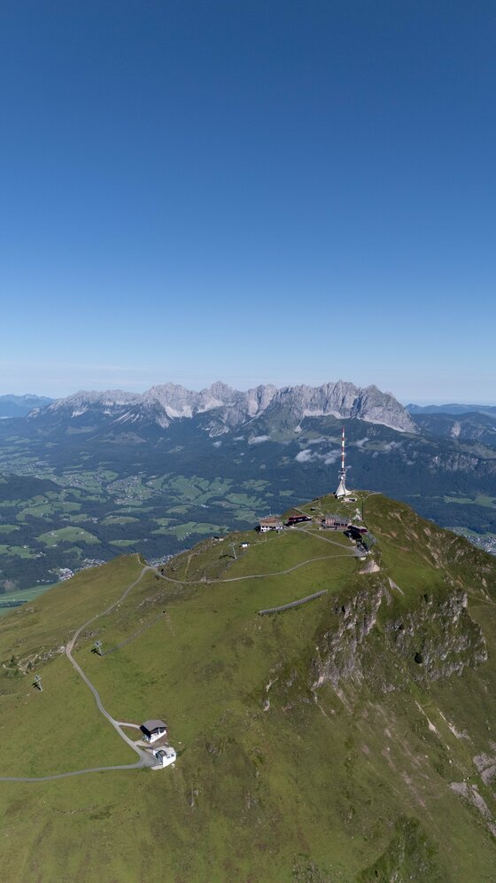 Gipfel des Kitzbüheler Horns Luftaufnahme des Kitzbüheler Horns mit Sendeturm, Bergstation und Wanderwegen vor dem Panorama des Wilden Kaisers.
