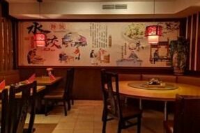 Shang Hai China Restaurant Innenansicht eines China-Restaurants mit runden Holztischen und einer großen Wandmalerei mit asiatischen Motiven.