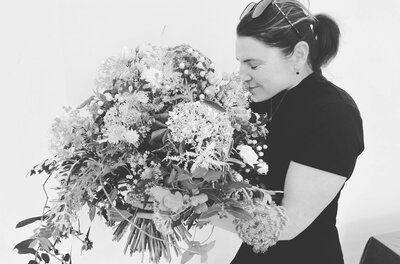 Helene mit Blumenstrauß Schwarz-Weiß-Aufnahme einer Frau, die an einem großen Blumenstrauß riecht.