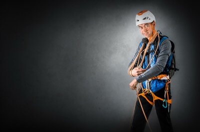 Anton Landmann Ein Kletterer in einer Sicherheitsausrüstung steht mit Seilen in der Hand. Er trägt einen Helm und schaut fokussiert in die Kamera.