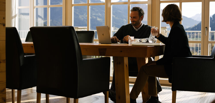 A meeting at a table with a view of the countryside