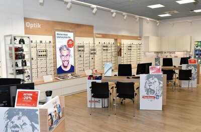 Hartlauer Optik-Fachgeschäft Innenansicht eines Hartlauer Optik-Fachgeschäfts mit Brillenregalen und Beratungstischen.