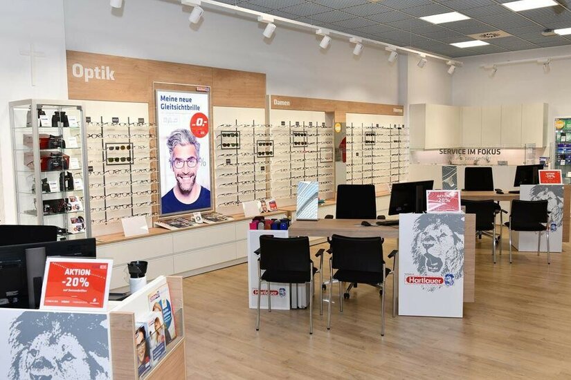 Hartlauer Optik-Fachgeschäft Innenansicht eines Hartlauer Optik-Fachgeschäfts mit Brillenregalen und Beratungstischen.