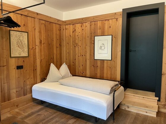 <p><p>Ein gemütliches Zimmer mit Holzlogen und einem Schlafsofa. Eine schwarze Tür führt zu einem weiteren Raum und an der Wand hängen zwei Bilder.</p></p>