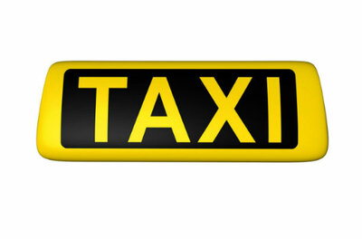 Taxi Entstrasser Gelbes Taxi-Schild mit schwarzer Aufschrift vor weißem Hintergrund.