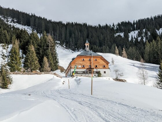 Bochumer Hütte im Winter Bochumer Hütte in verschneiter Berglandschaft mit Nadelwald im Hintergrund.