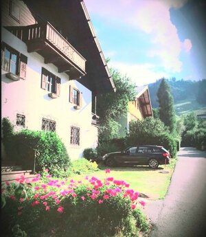 Haus mit Parkplätzen und "Streif" im Hintergrund