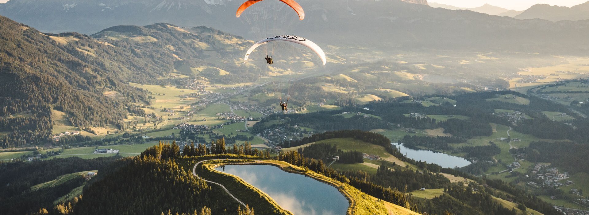 Zwei Paragleiter über dem Kitzbüheler Seidlalmsee