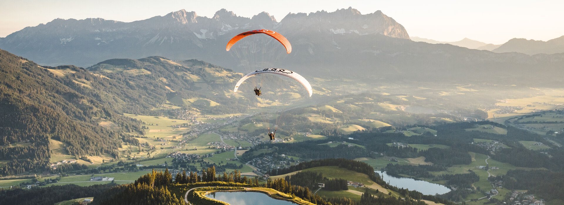 Zwei Paragleiter über dem Kitzbüheler Seidlalmsee