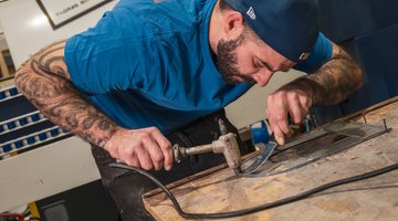 Ein Mann geht in seiner Glaserei seinem Handwerk nach