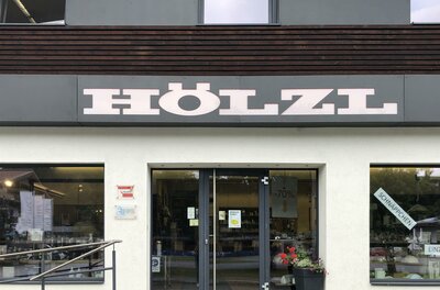 Elektro Hözl Ein Geschäft mit dem Namen "HÖLZL". Die Eingangstür ist einladend und hat große Fenster.
