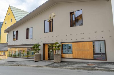 Außenansicht des Frauenschuh-Geschäfts mit moderner Fassade und dekorativen Schuhelementen.