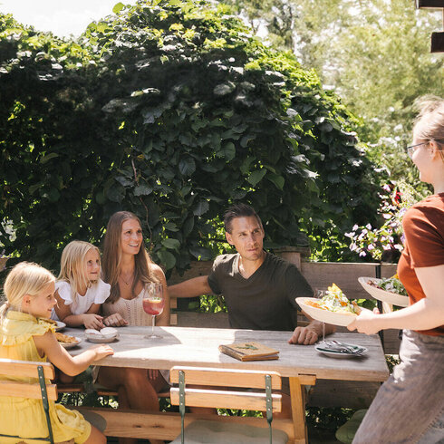 A family is sitting in a restaurant in Kitzbühel on a beautiful day