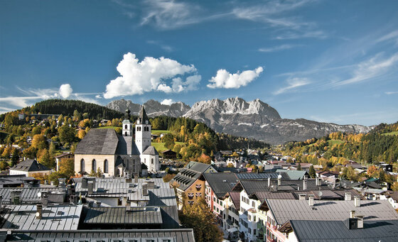 Kitzbühel mit Wildem Kaiser Blick über die Dächer von Kitzbühel mit der Stadtpfarrkirche und dem Wilden Kaiser im Hintergrund.