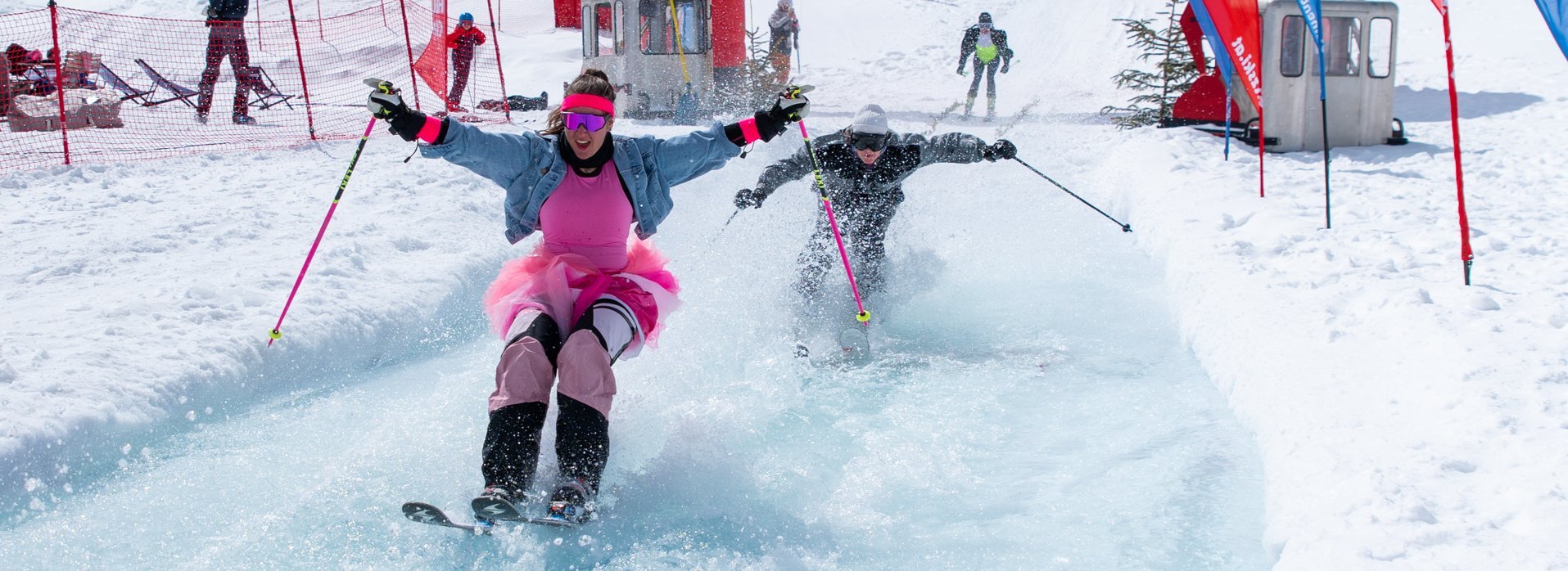 A woman in a skirt skiing over a natural pool on the slope