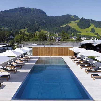 Der Pool mit klarem Wasser und eleganten Liegen bietet eine perfekte Kulisse für Entspannung inmitten der schönen Berglandschaft.