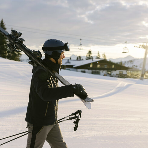 A skier carrying skis