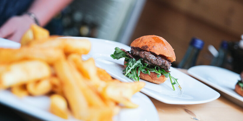 Ein saftiger Burger mit Rucola und Pommes beim Kulinarik-Festival in Kitzbühel.