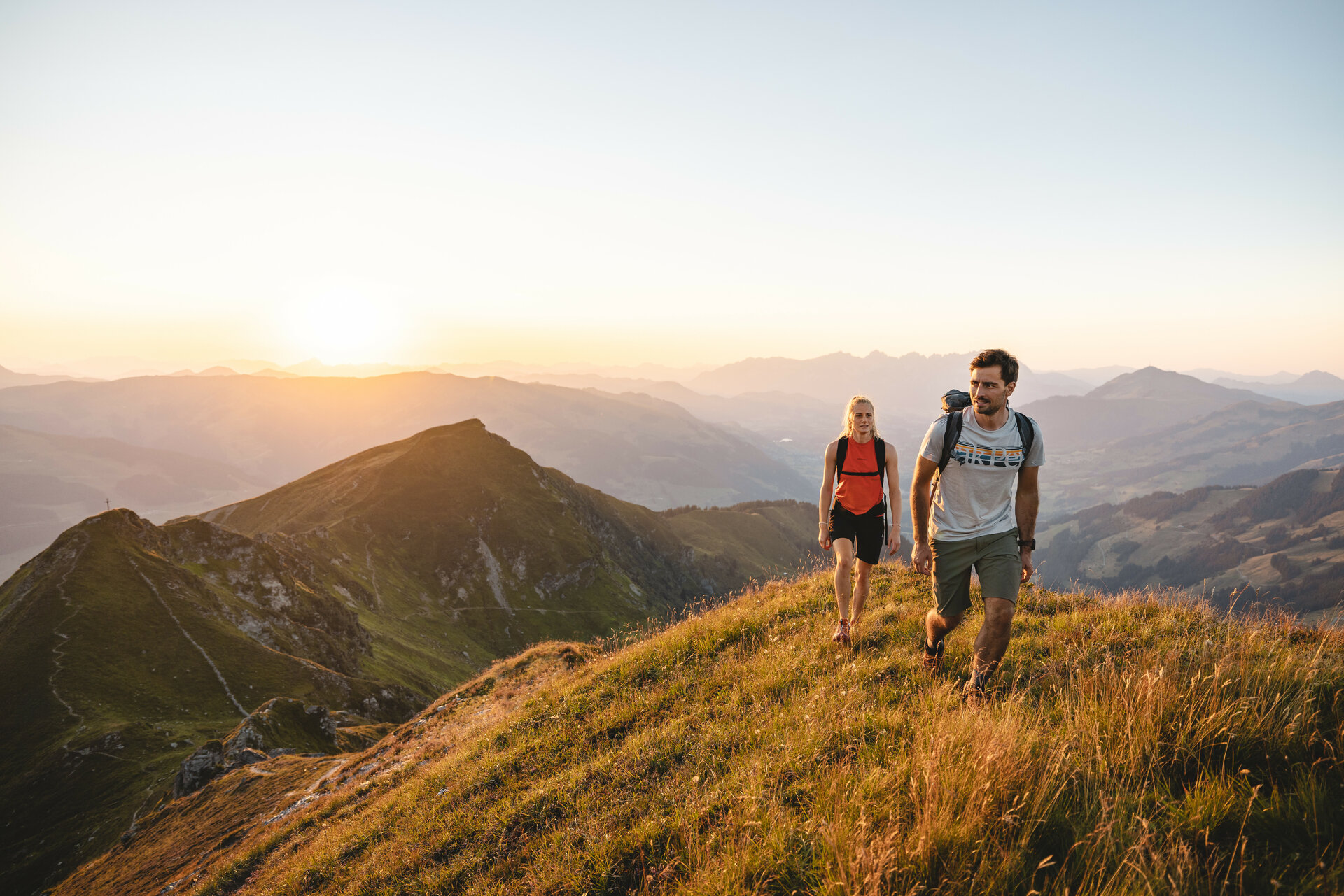 Two people are hiking at sunrise