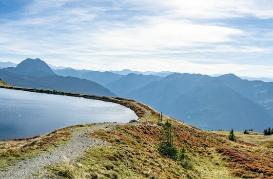 Speichersee am Pengelstein Blick über einen Speichersee am Pengelstein auf die umliegende Berglandschaft bei Tageslicht.
