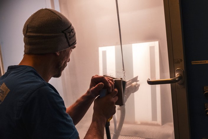 Ein Mann beim Arbeiten am Glas in einer Glaserei