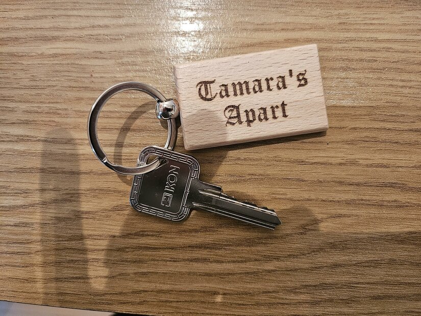 Ein Schlüsselbund mit einem Schlüssel und einem Holzanhänger. Der Anhänger trägt die Aufschrift "Tamara's Apart".